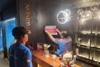 Fahmi Faisuri Kabid Wasdal Bapenda Kabupaten Tangerang menempelkan stiker pemberitahuan WP penunggak pajak diruang usaha Restoran Parison Gading Serpong Kecamatan Pagedangan, Jumat 21 Februari 2025