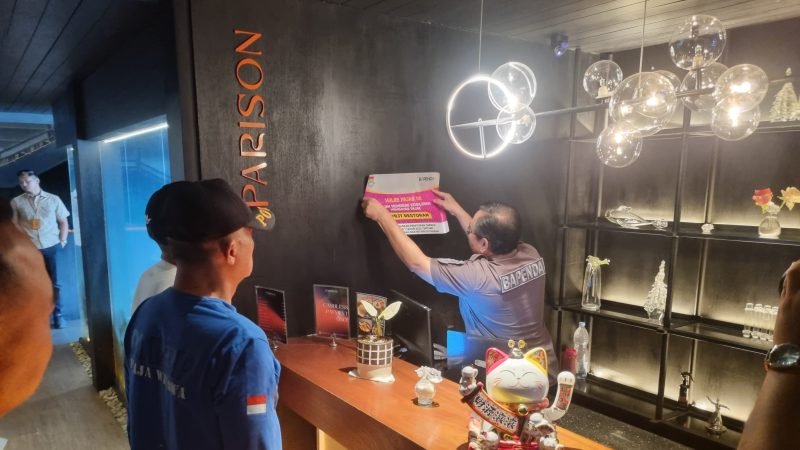 Fahmi Faisuri Kabid Wasdal Bapenda Kabupaten Tangerang menempelkan stiker pemberitahuan WP penunggak pajak diruang usaha Restoran Parison Gading Serpong Kecamatan Pagedangan, Jumat 21 Februari 2025