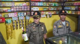 Petugas Satpol PP melakukan penyitaan minuman beralkohol yang dijual warung Jamu