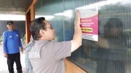 Fahmi Faisuri, Kepala Bidang Wasdal pada Bapenda Kabupaten Tangerang nampak yang memasang stiker pemberitahuan disalah satu restoran yang menunggak pajak, Jumat (21/02/2025)