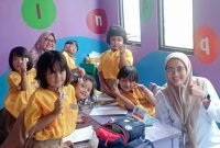 Tim medis puskesmas Cisauk berpose dengan anak sekolah usai memberi obat cacing