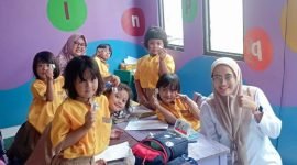 Tim medis puskesmas Cisauk berpose dengan anak sekolah usai memberi obat cacing