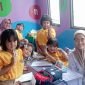 Tim medis puskesmas Cisauk berpose dengan anak sekolah usai memberi obat cacing