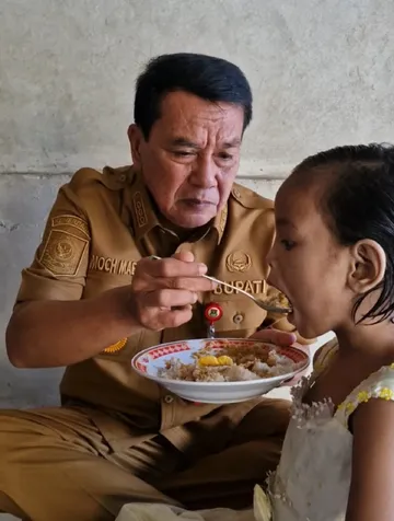 Bupati Maesyal Rasyid menyuapi makan anak Davina yang viral dimedsos dipasung. (Foto ; TangerangKab.go.id)
