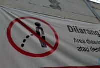 Foto: Warga melewati spanduk larangan kencing di pinggir Jakarta, 'Kena' Rp 20 Juta di kawasan Lebak Bulus, Jakarta, Kamis (23/2/2023). (CNBC Indonesia/Suhendra)