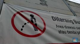 Foto: Warga melewati spanduk larangan kencing di pinggir Jakarta, 'Kena' Rp 20 Juta di kawasan Lebak Bulus, Jakarta, Kamis (23/2/2023). (CNBC Indonesia/Suhendra)