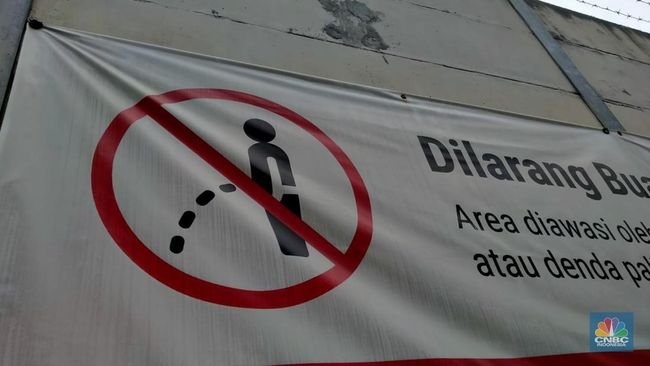 Foto: Warga melewati spanduk larangan kencing di pinggir Jakarta, 'Kena' Rp 20 Juta di kawasan Lebak Bulus, Jakarta, Kamis (23/2/2023). (CNBC Indonesia/Suhendra)