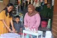 Ibu Khalimatus sedang melayani pembeli di warungnya