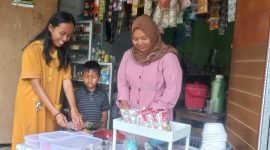 Ibu Khalimatus sedang melayani pembeli di warungnya
