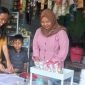Ibu Khalimatus sedang melayani pembeli di warungnya