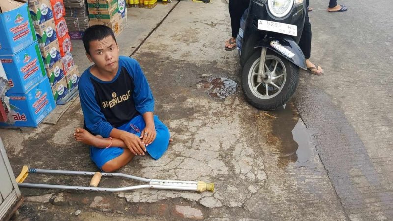 Kefin (23 tahun) Tuna Grahita yang menderita cacat kakinya yang viral sering mangkal ditengah jalan Tapos Tigaraksa (sumber foto ; warga yang peduli dan memindahkan Kefin ke pinggir jalan)
