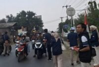 Aktifis Komunitas Rakyat Memberi dan Karang Taruna Kecamatan Curug membagikan bendera merah putih kepada para pengendara yang melewati Jalan PLP Curug Kabupaten Tangerang 